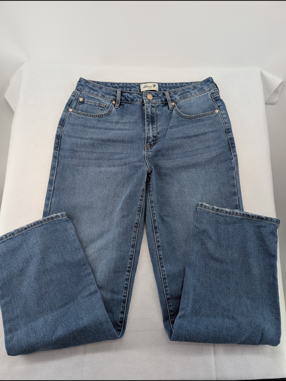 Seven7 jeans feature a classic five-pocket design and a medium-wash blue denim.